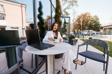 Stylish Business Woman Enjoying Coffee at a Modern Outdoor Café