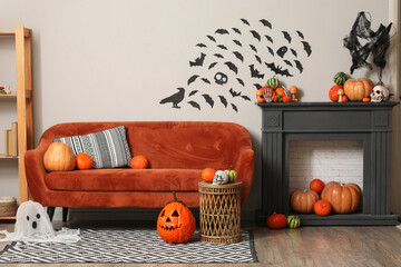 Interior of festive living room with orange sofa, fireplace and different Halloween decorations