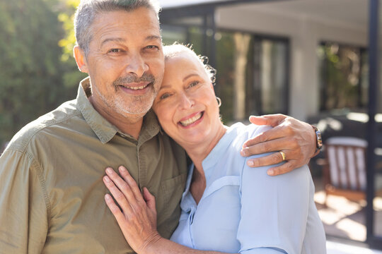 Embracing outdoors, smiling senior couple enjoying time together, at home
