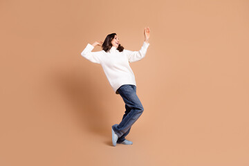 Photo of positive happy charming senior woman wear trendy clothes have fun dance isolated on beige color background