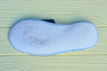 one slipper with white fabric sole lies on the yellow wooden floor