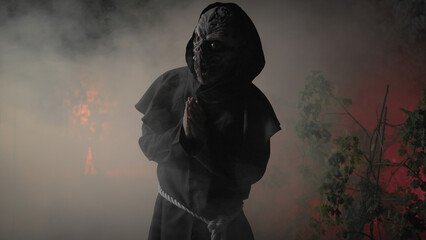 Monk With monster face walk in the night forest for Halloween