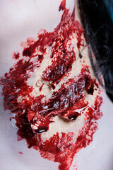 Close up shot of bloody injury on pale neck achieved through SFX makeup techniques for horror movie...