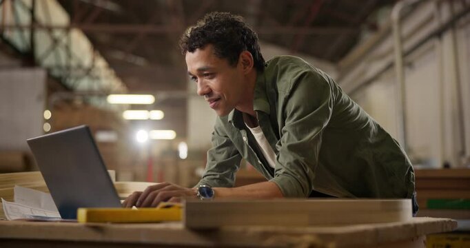Man, laptop and carpenter, planning and networking in workshop for typing project idea. Male woodworker, communication or read feedback on computer, customer and worker in warehouse for manufacturing