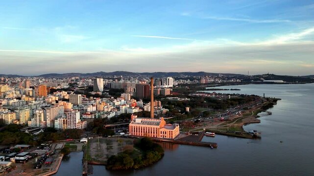 Old power station by river wide, once filled with hums of electric pride