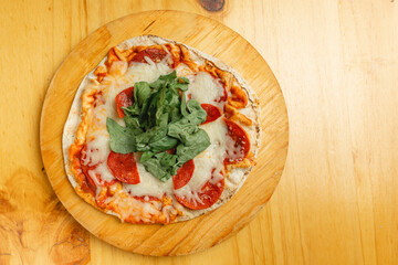 A delicious pizza placed on a rustic wooden cutting board on a wooden table