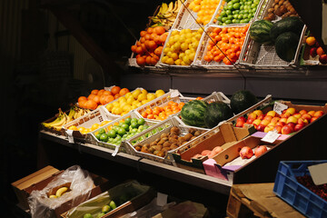  Fruit market display with colorful fruits in crates. Grocery store with oranges, lemons, limes, kiwis, and watermelons. Fresh and vibrant produce at the farmer's market.