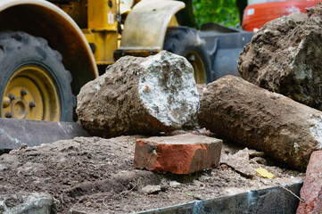 demolition of a gravestone with an excavator after expiry of the period of use in a cemetery