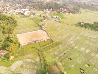 Photography of a Football field in the middle of rice fields from an aerial perspective. View of...