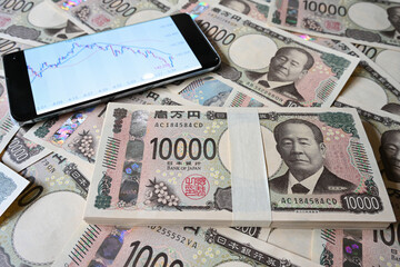 大量の新一万円札と為替相場のチャート　10,000 yen bills(new design) and a chart of the exchange rate