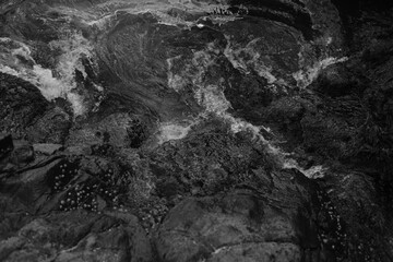 Stormy waves on a rocky seashore. Black and white sea