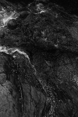 Stormy waves on a rocky seashore. Black and white sea