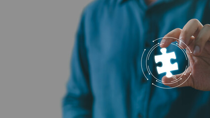 A person holds a glowing puzzle piece, symbolizing problem-solving and innovation in a modern,...