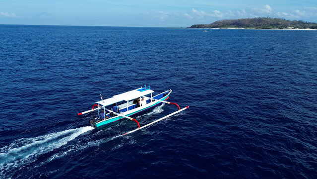 Indonesian fishing trimaran in motion. Tourists travel to the Gili Islands on a trimaran with a local guide. Indonesia Travel