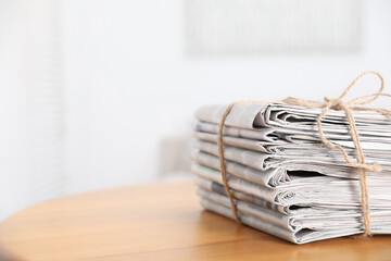 Stack of many newspapers on wooden table, space for text