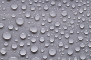Water drops on gray background, top view