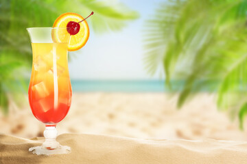 Summer beach with delicious Tequila Sunrise cocktail, palm leaves and golden sand, space for text
