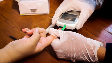 Close-up of a doctor wearing gloves, using a glucometer to measure a patient's blood glucose levels during a routine medical checkup. Focus on medical device, hygiene, and diabetes screening