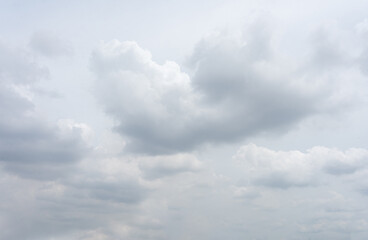 Fluffy white clouds drift across a bright blue sky, painting a beautiful summer day