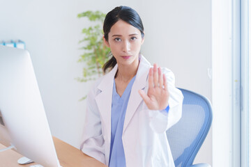 止める女性医師.