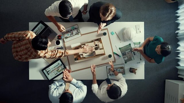 Top view of smart manager clapping hands and putting hands together to celebrate project. Aerial view of architect engineer brainstorming about interior construction. Team work, unity. Alimentation.