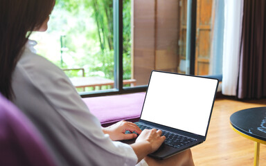 Mockup image of a woman using and typing on computer laptop with blank desktop screen at home