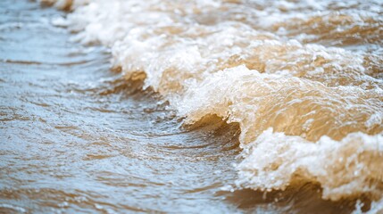 Obraz premium A close-up view of rolling waves in a muddy, brown body of water, showcasing the movement and texture of the surf.
