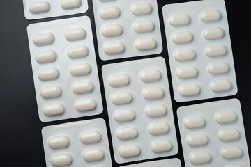 Pills Medicine tablet capsules in blister pack on a black background