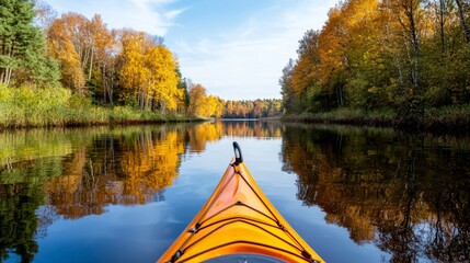 A serene kayak glides across a reflective lake surrounded by vibrant autumn foliage under a clear blue sky.