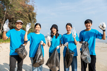 Group teamwork volunteer pick up the plastic bottle on the beach. People male and female Volunteer with garbage bags clean the trash on the beach make the sea beautiful. World environment day CSR.