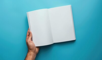 Person holding open book with blank pages on a bright blue background. Flat lay composition with space for text.