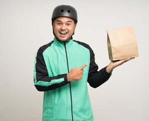 Young asian rider wearing green jacket uniform and bike helmet various action holding food paper bag delivery to customer. Male delivery service worker. Courier and shipping food service.