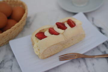 Strawberry cheese cake with cup of coffee on marble table.