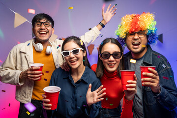Obraz premium New Year's Party. Group of asian friend party in the house with disco light having fun and dancing together. Enjoy Singing karaoke listening music drinking beer celebration in new year happy hour.