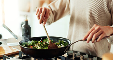 Spoon, cooking and hands of woman in kitchen with food, health and wellness with traditional recipe...