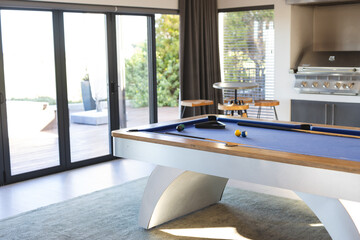 Playing pool on modern billiards table in stylish living room, at home