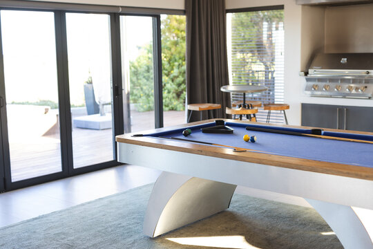 Playing pool on modern billiards table in stylish living room, at home