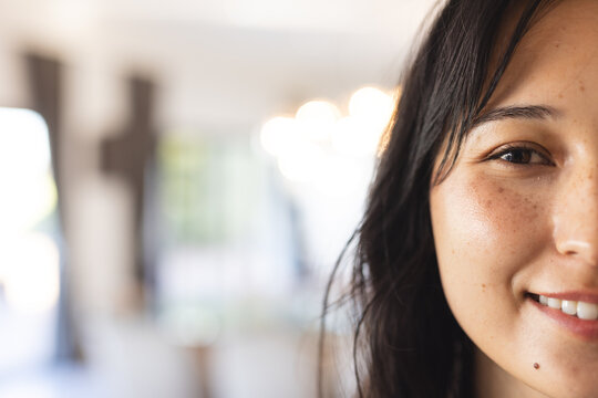 Smiling woman with long hair enjoying time with diverse friends indoors, copy space, at home