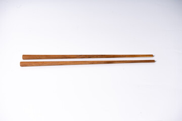 Two chopsticks are sitting on a white background. The chopsticks are wooden and are placed parallel to each other