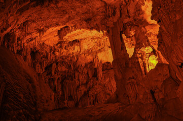 Stalactites hanging from the vaults of the cave illuminated by artificial light