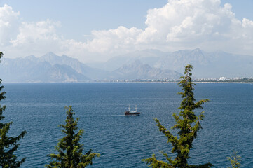 View of the blue sea from a hill with mountains in the background