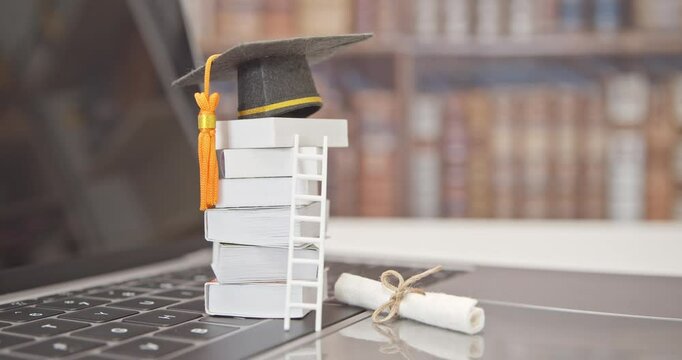 Graduate study abroad program to broaden learner's world view, e-learning concept : Graduation cap, foreign books on a laptop, depicts student attempting to study from a distance or learning from home