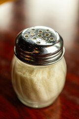 parmesan cheese in a shaker bottle on a table 