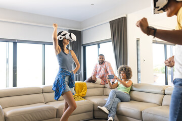 Playing VR games, diverse friends enjoying virtual reality experience in living room, at home
