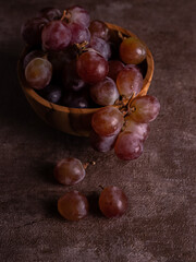 fresh red wine in a wooden bowl. red grape with rustic background