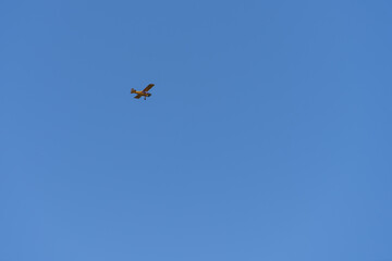 Small airplane flying against a clear blue sky