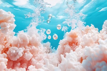A vibrant underwater scene featuring soft pink coral formations, clear blue water, and bubbles rising to the surface.