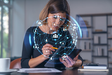 Businesswoman using tablet with digital network hologram.