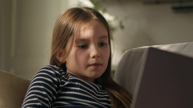 Caucasian little girl laptop watching comedy movie series cinema laugh humor video online internet computer pc child kid daughter offspring descendant schoolgirl gadget social networks browse message