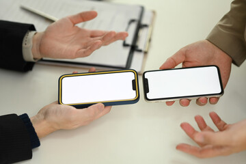 Two young people sharing data between smartphones. Technology, data transfer or collaboration concept